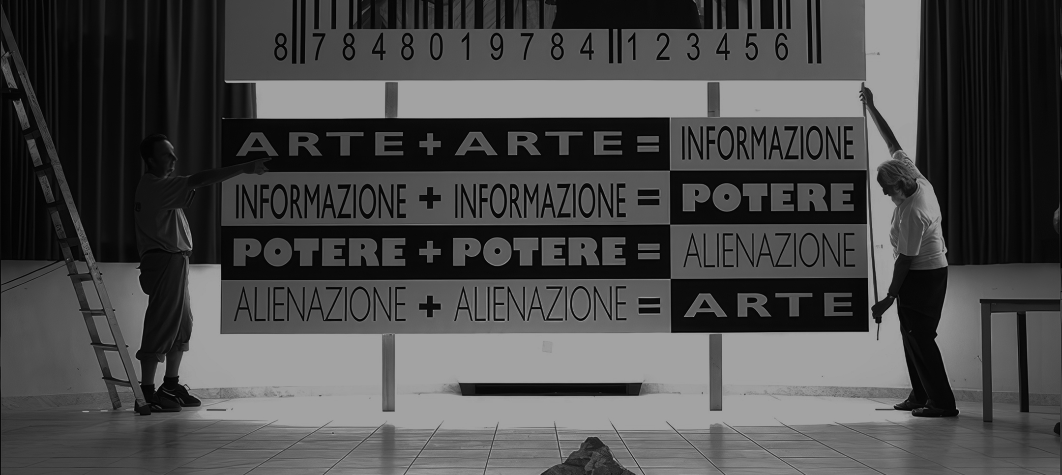 Art installation with large typographic panels on power, information, and alienation, supported by two people during setup, symbolizing the link between contemporary art and social reflection."